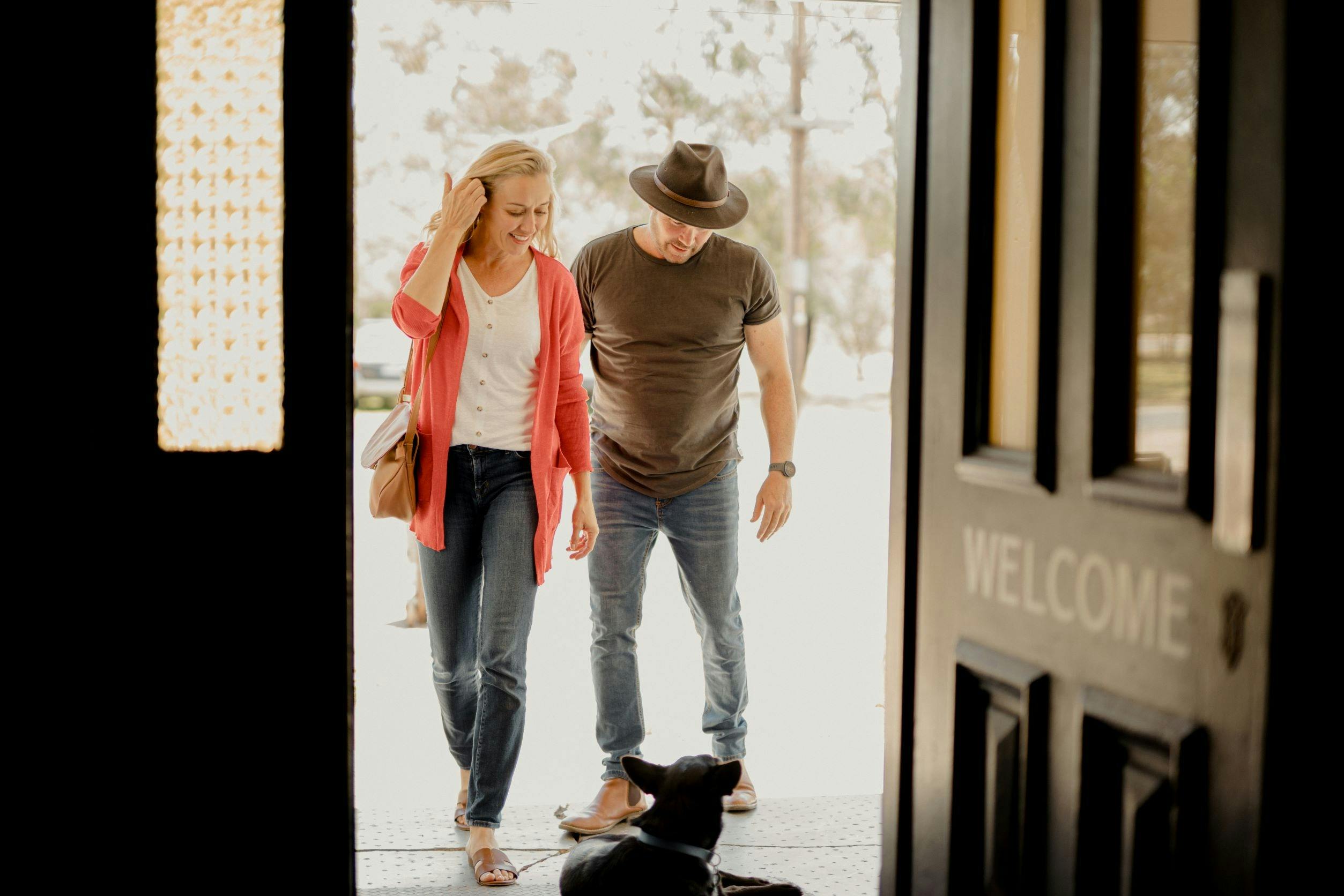 dog sittingth edoorway to the Balldale Hotel reating a middle aged couple walking in to the pub