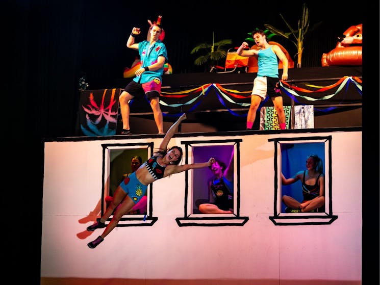 Acrobats perform on a tramp wall.