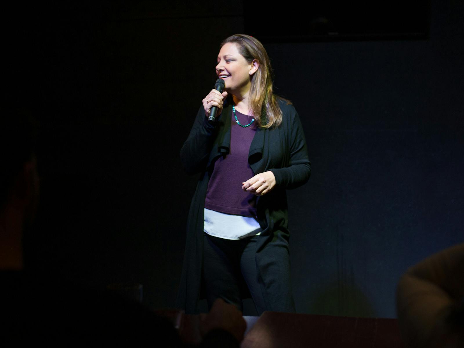 Comedian Christina Van Look smiling while performing on stage