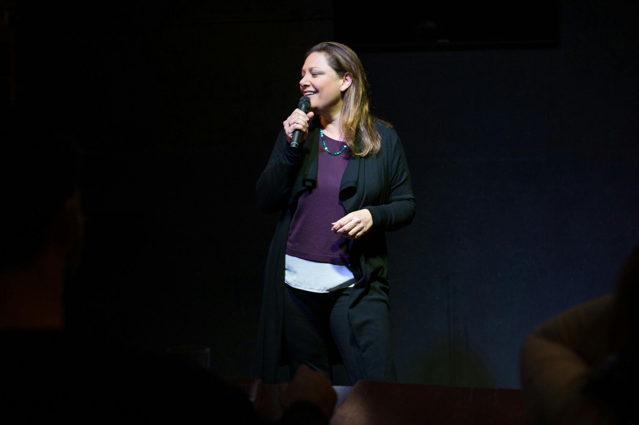 Comedian Christina Van Look smiling while performing on stage