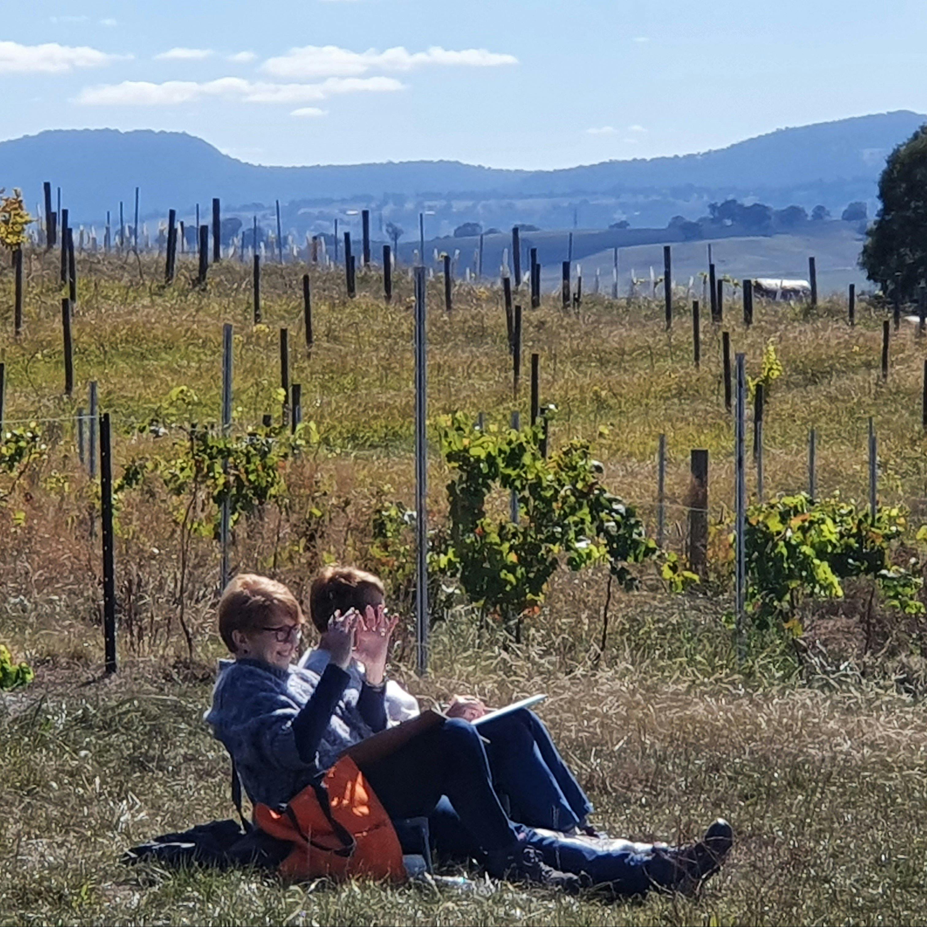 two artists painting among vines