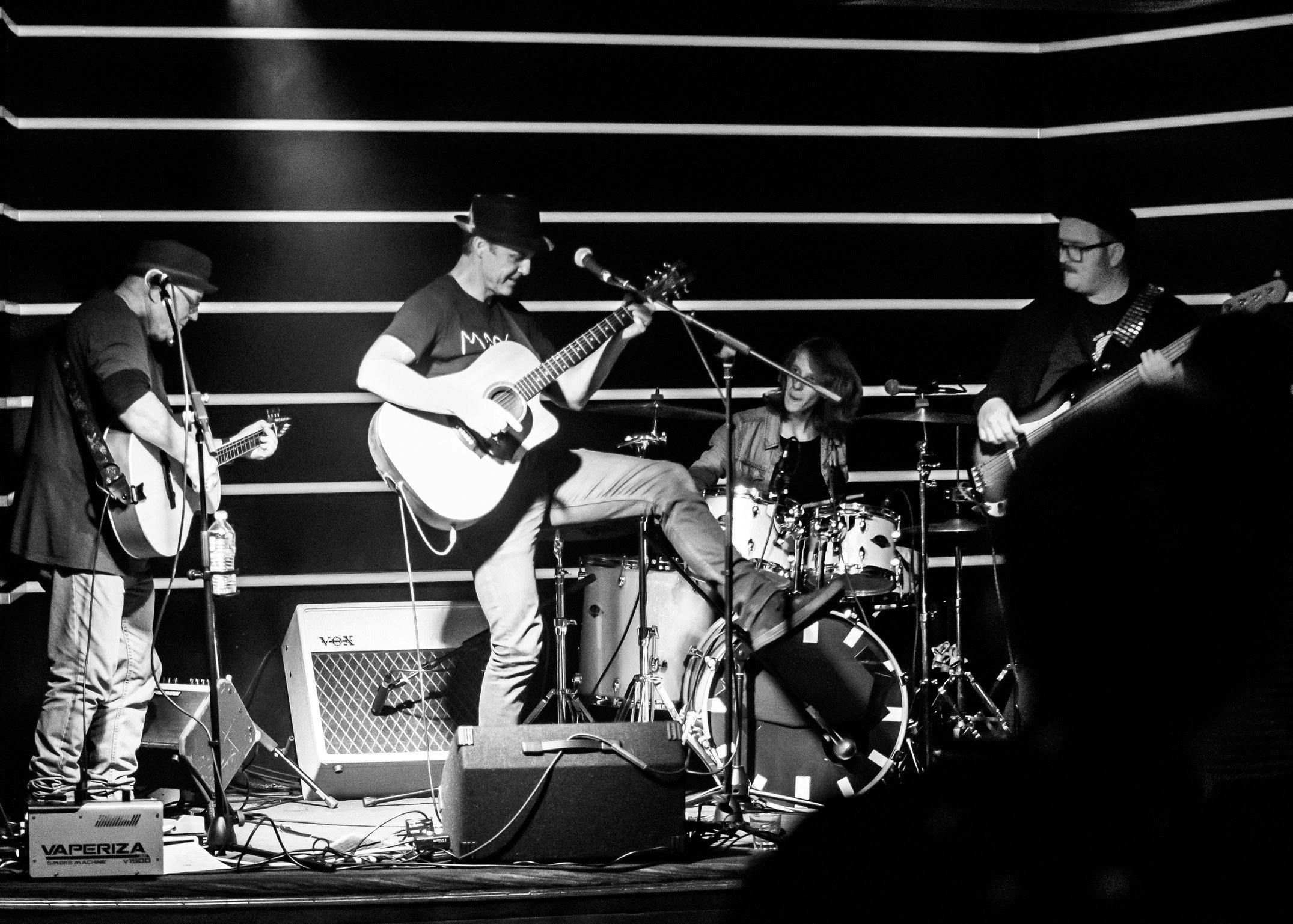Black and white image of a band on stage