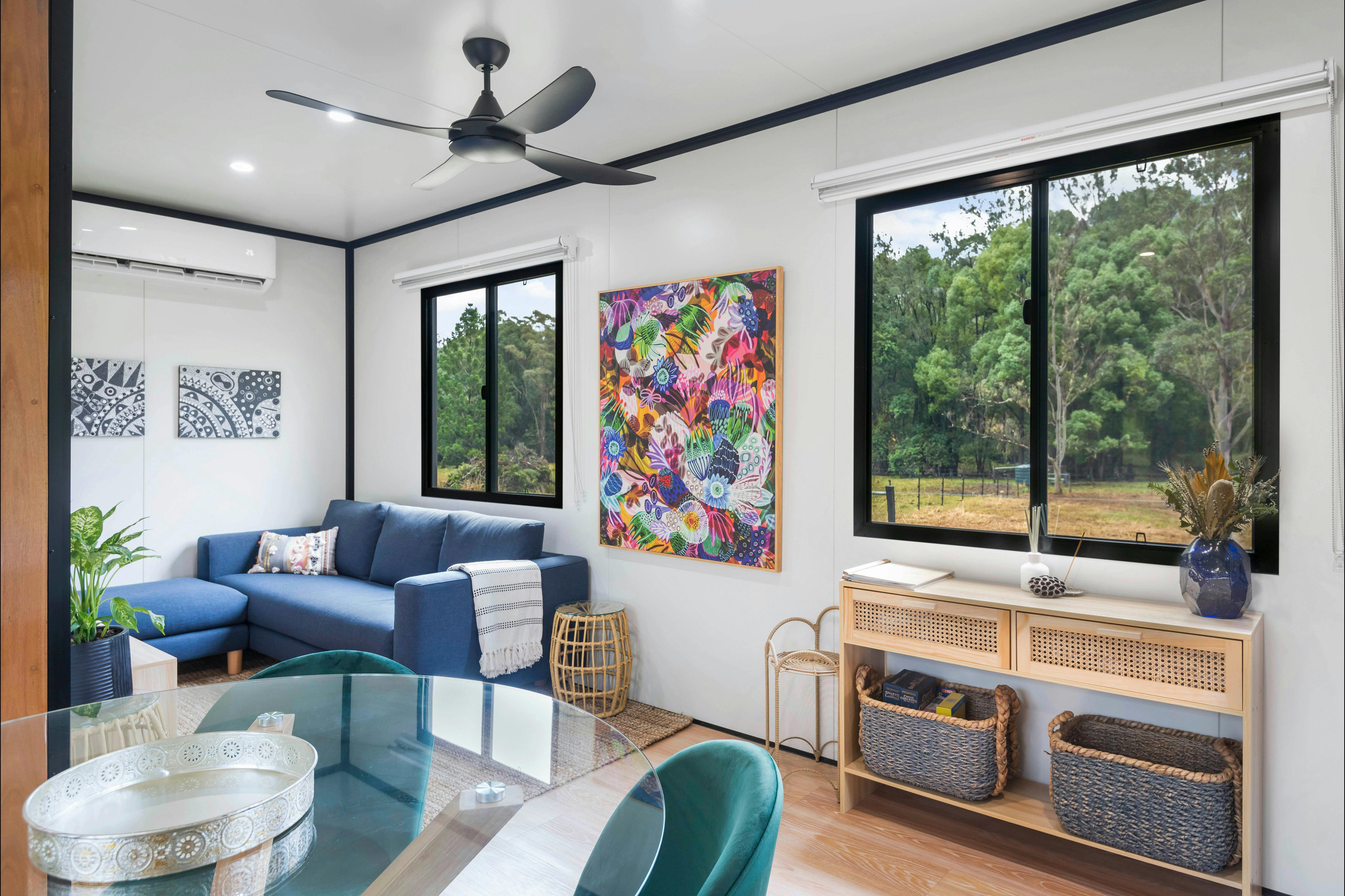 Internal image of lounge, dining, entry way and artwork, overlooking the paddocks of the farm