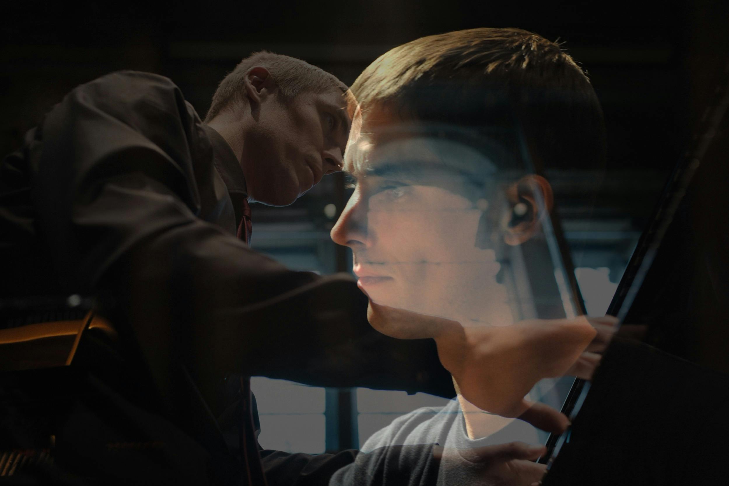 Double exposure photograph of pianist Cédric Tiberghien. One image shows him in profile, focused whi