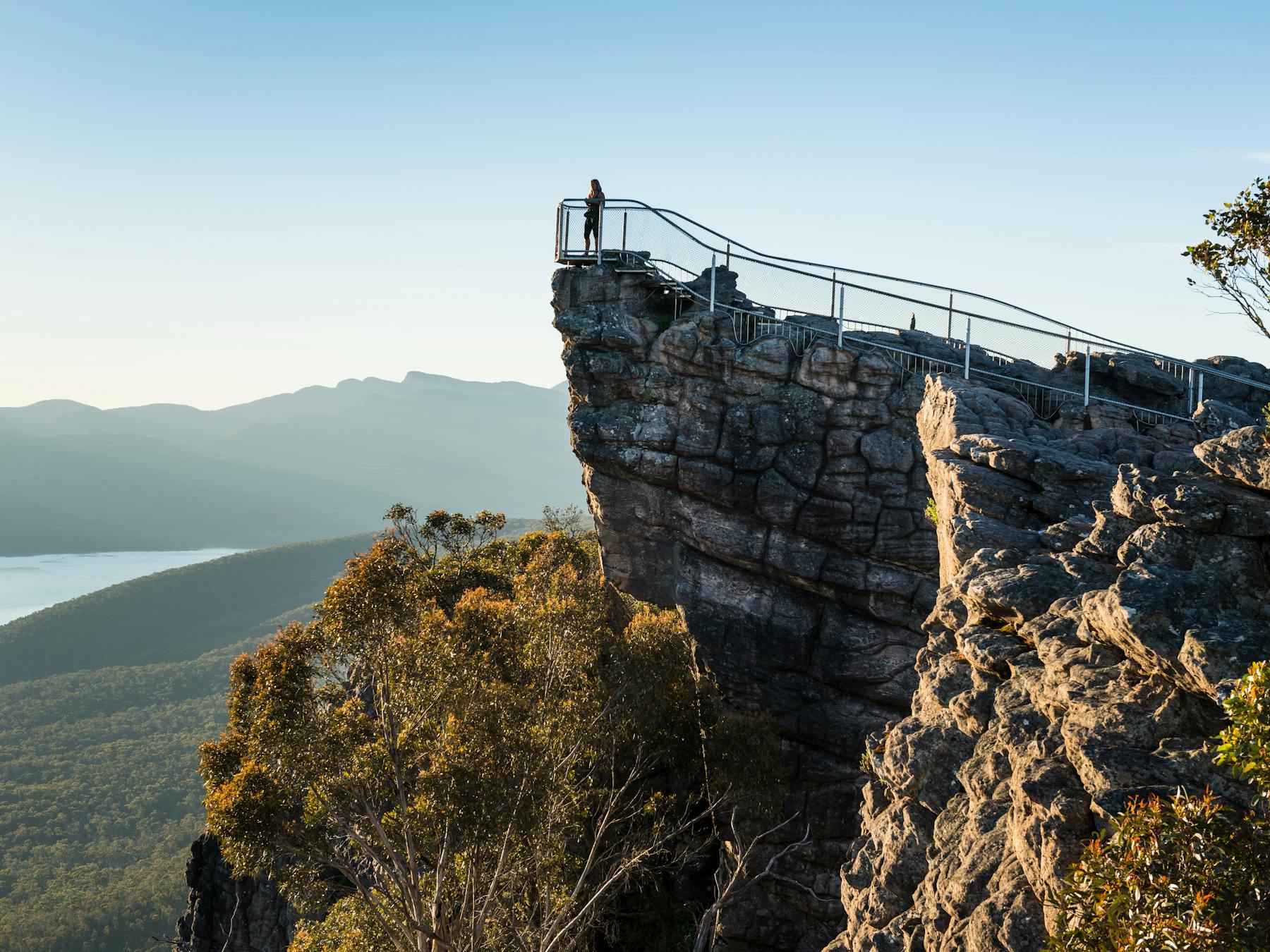 Image of a person standing on a rocky outcrop high in the Grampians