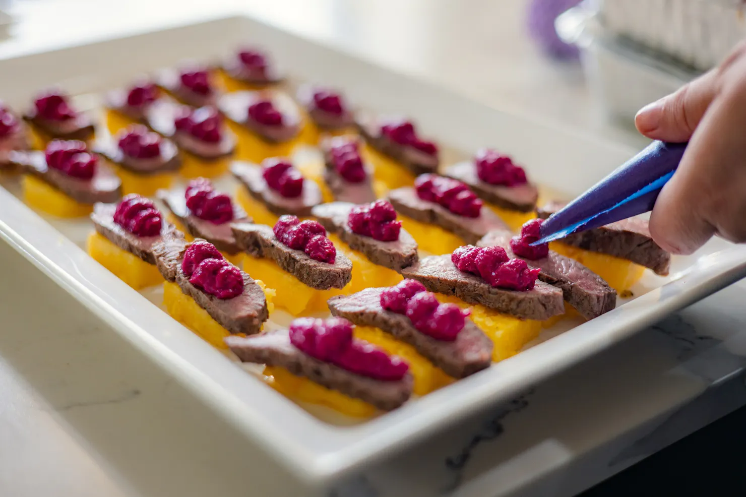 A plate of canapes getting finishing touch from Chef