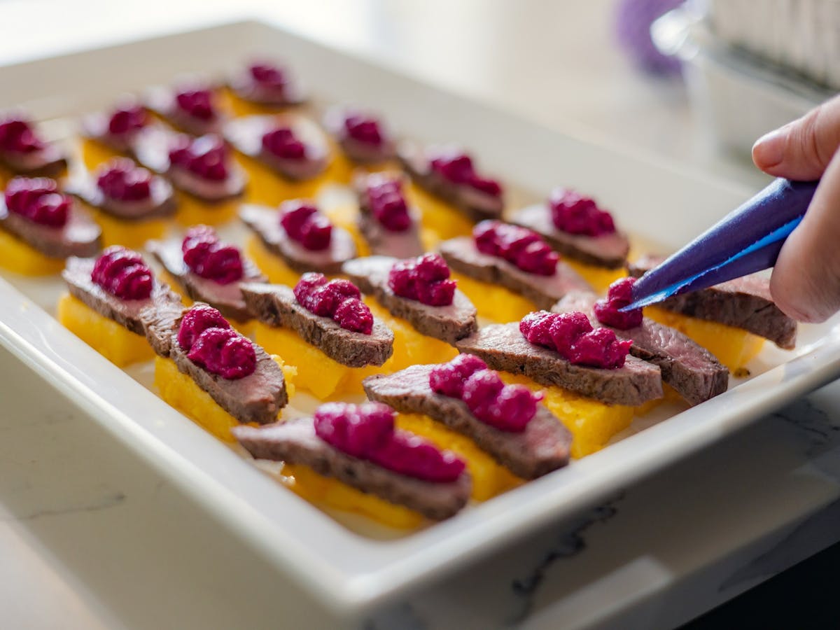 A plate of canapes getting finishing touch from Chef