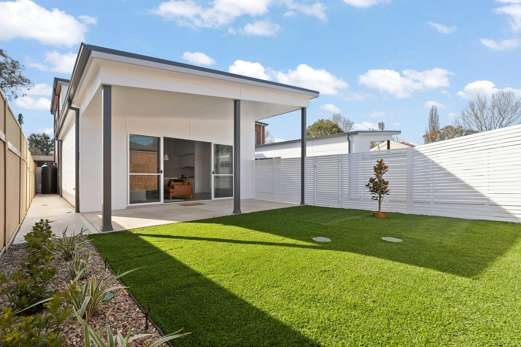 Large green grass area with undercover patio