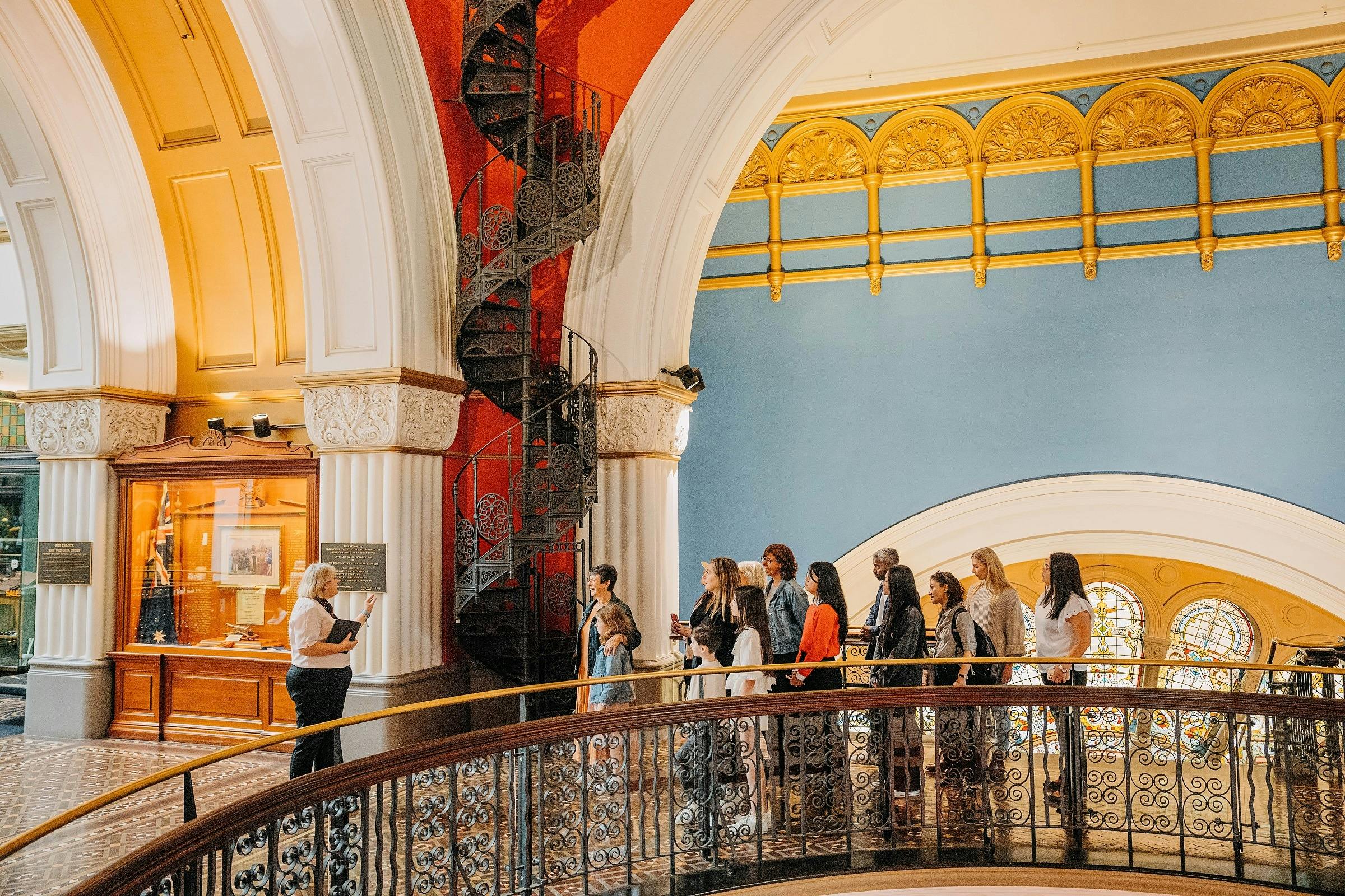 A QVB History Tour group at the spiral staircase on level two