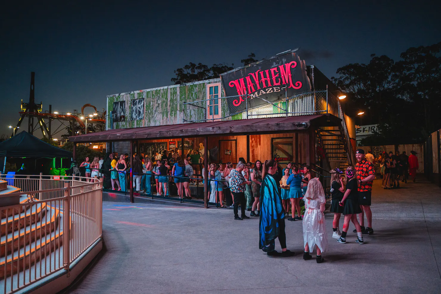 People in a queue outside the Mayhem Maze attraction.