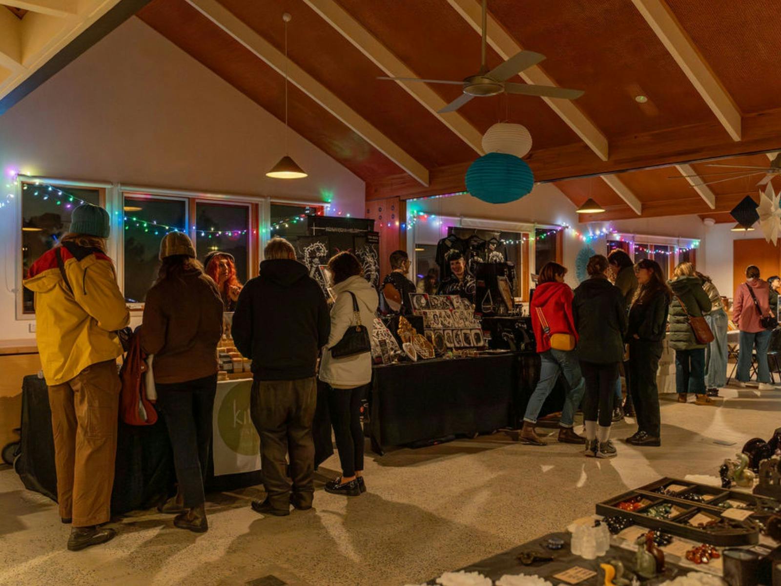 Market-goers shop indoors at local stalls.