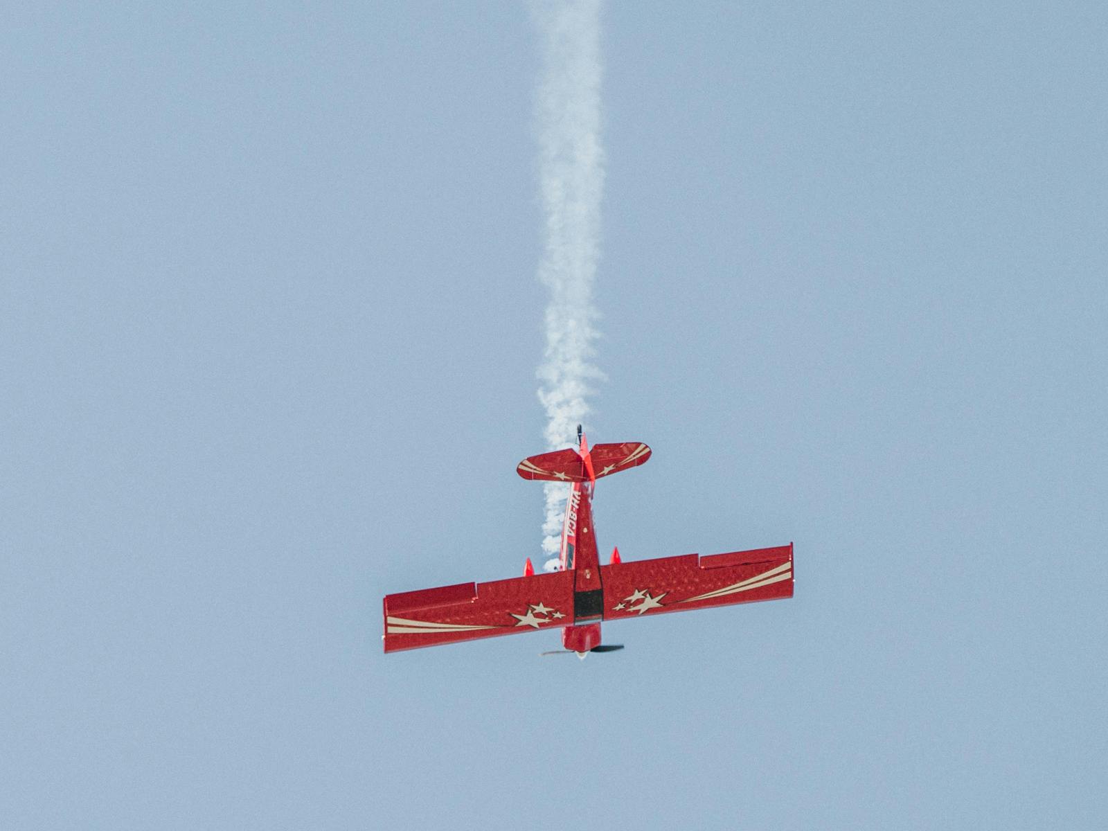 Pilot demonstrating an aerobatic move with smoke