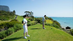 Couple enjoying a round of golf at Lord Howe Island Golf Course with ocean views
