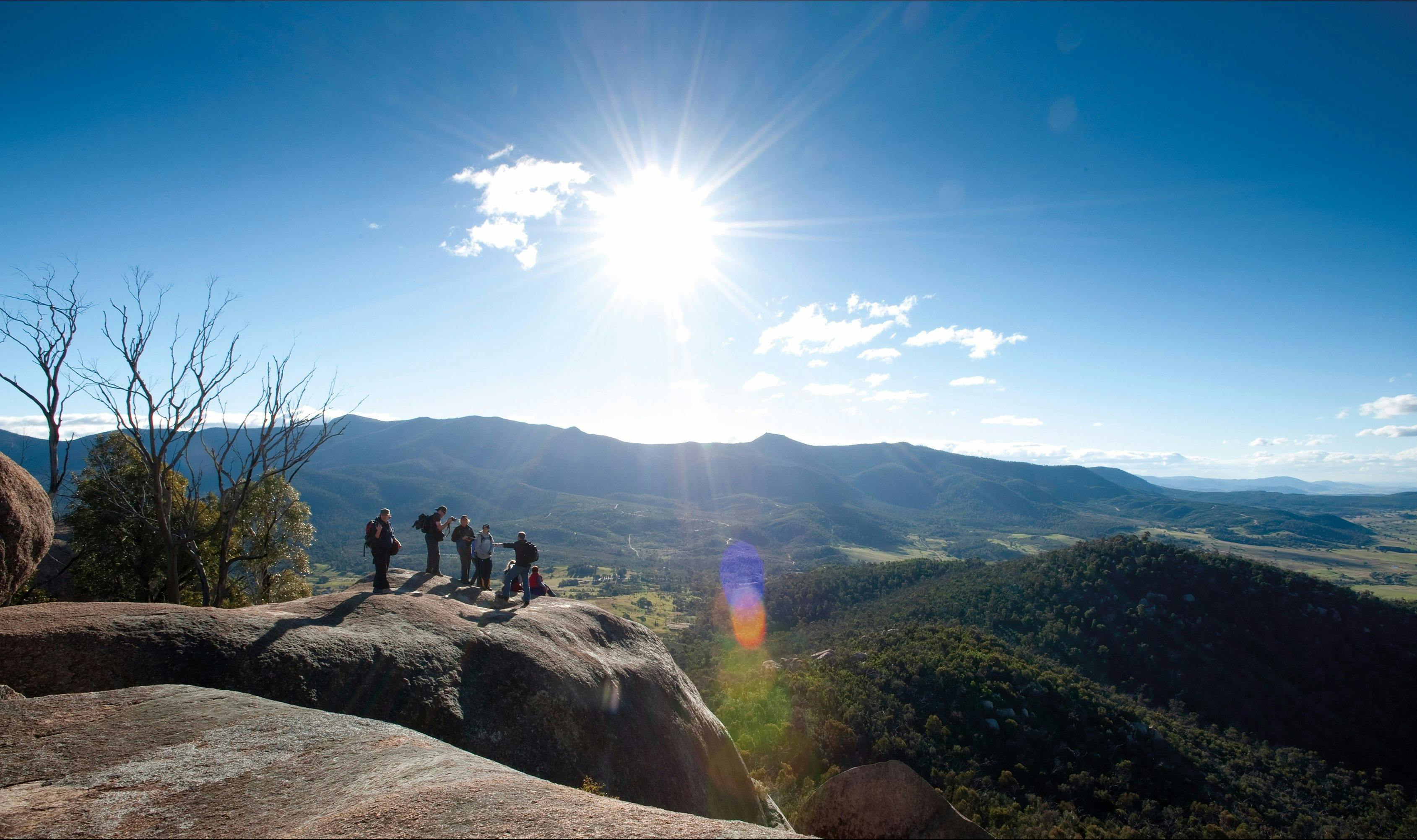 Small group of people looking out over magnificent views of the valley and mountain ranges