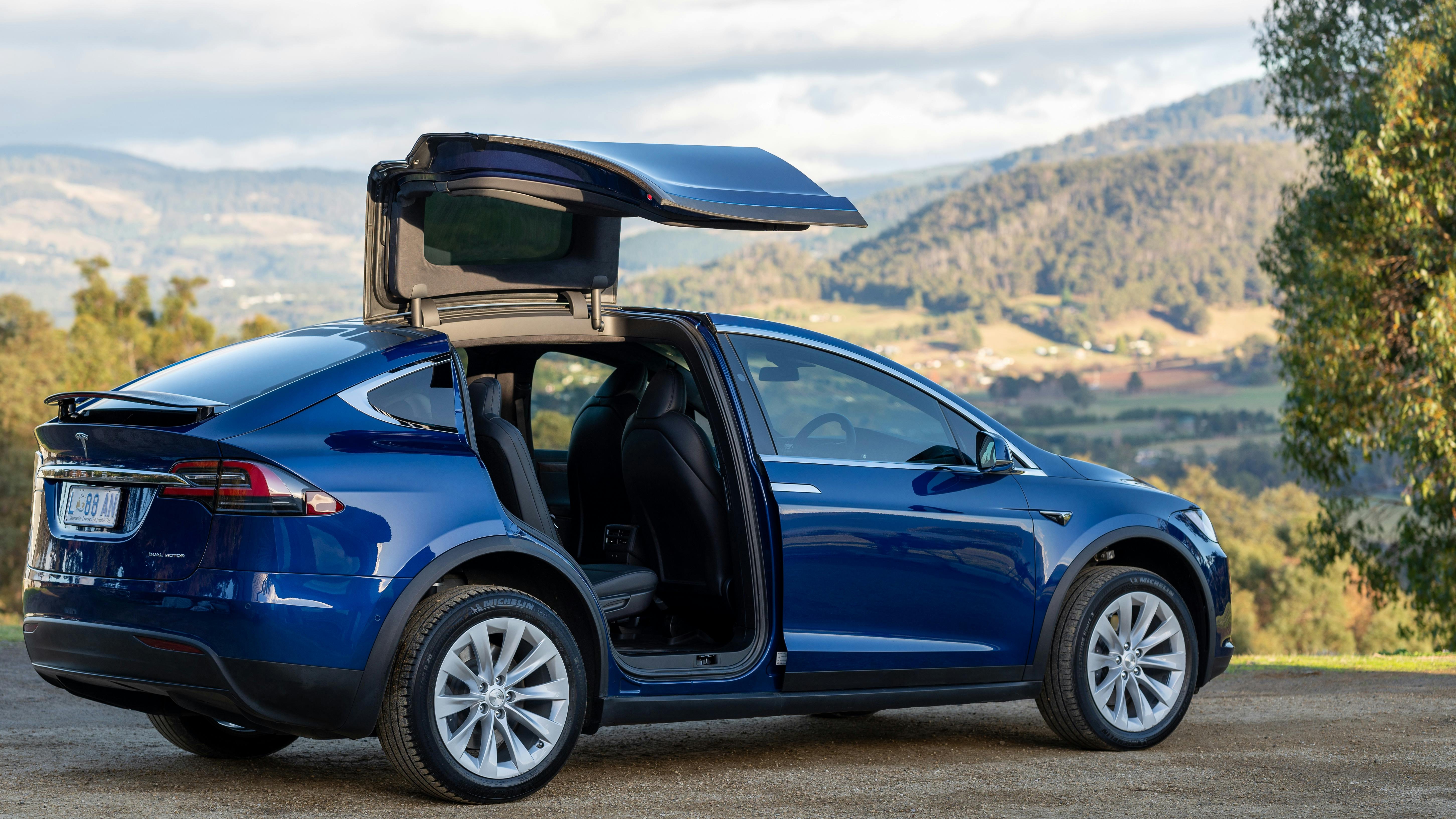 EVRide Tesla Model X with open falcon-wing door in rural setting
