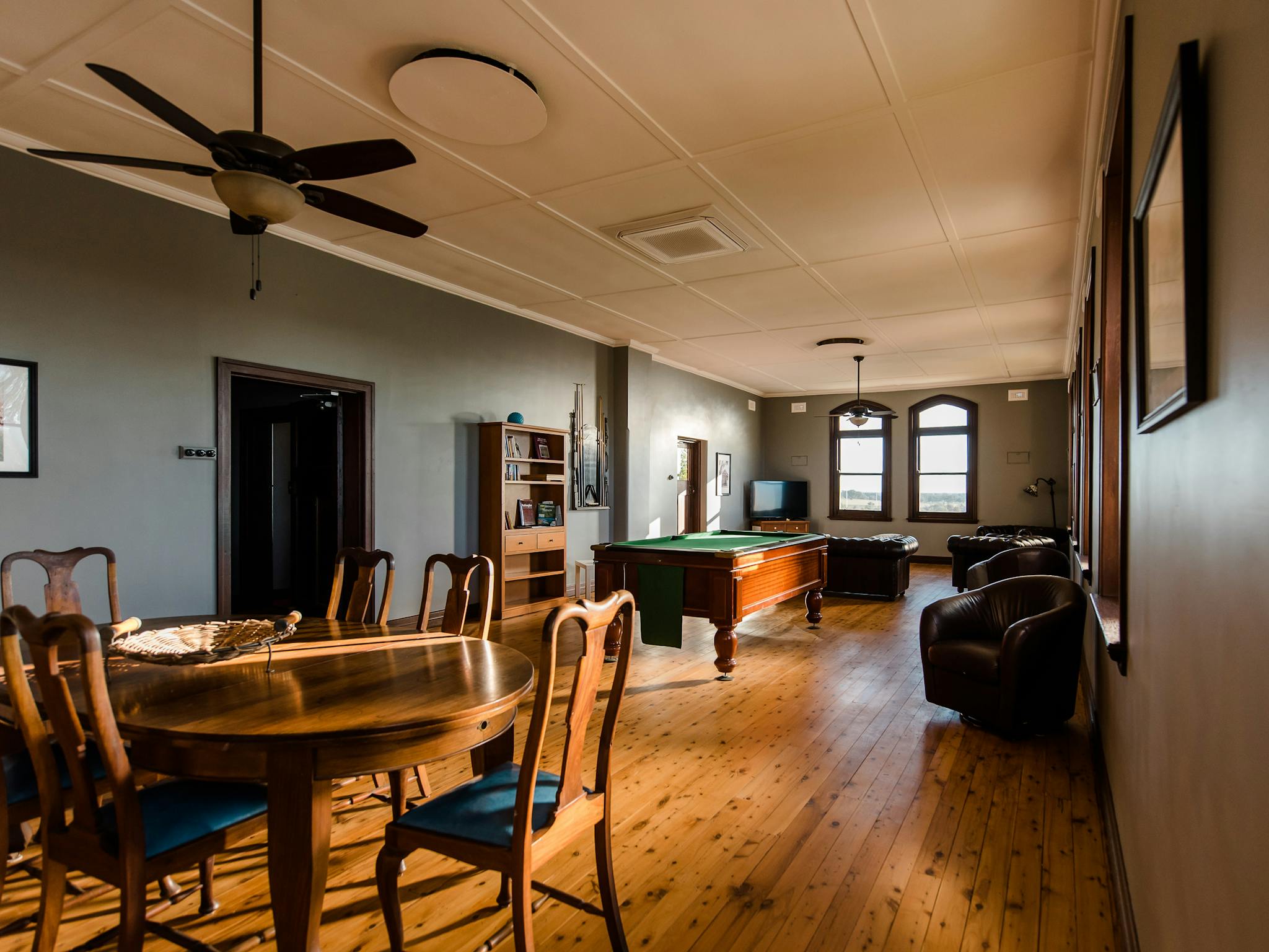 Upstairs lounge room with dining table, pool table, television, couch and arm chairs