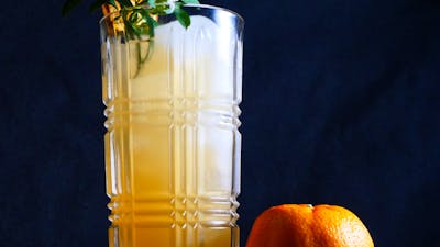 Cocktail in a tall glass with a mandarin.