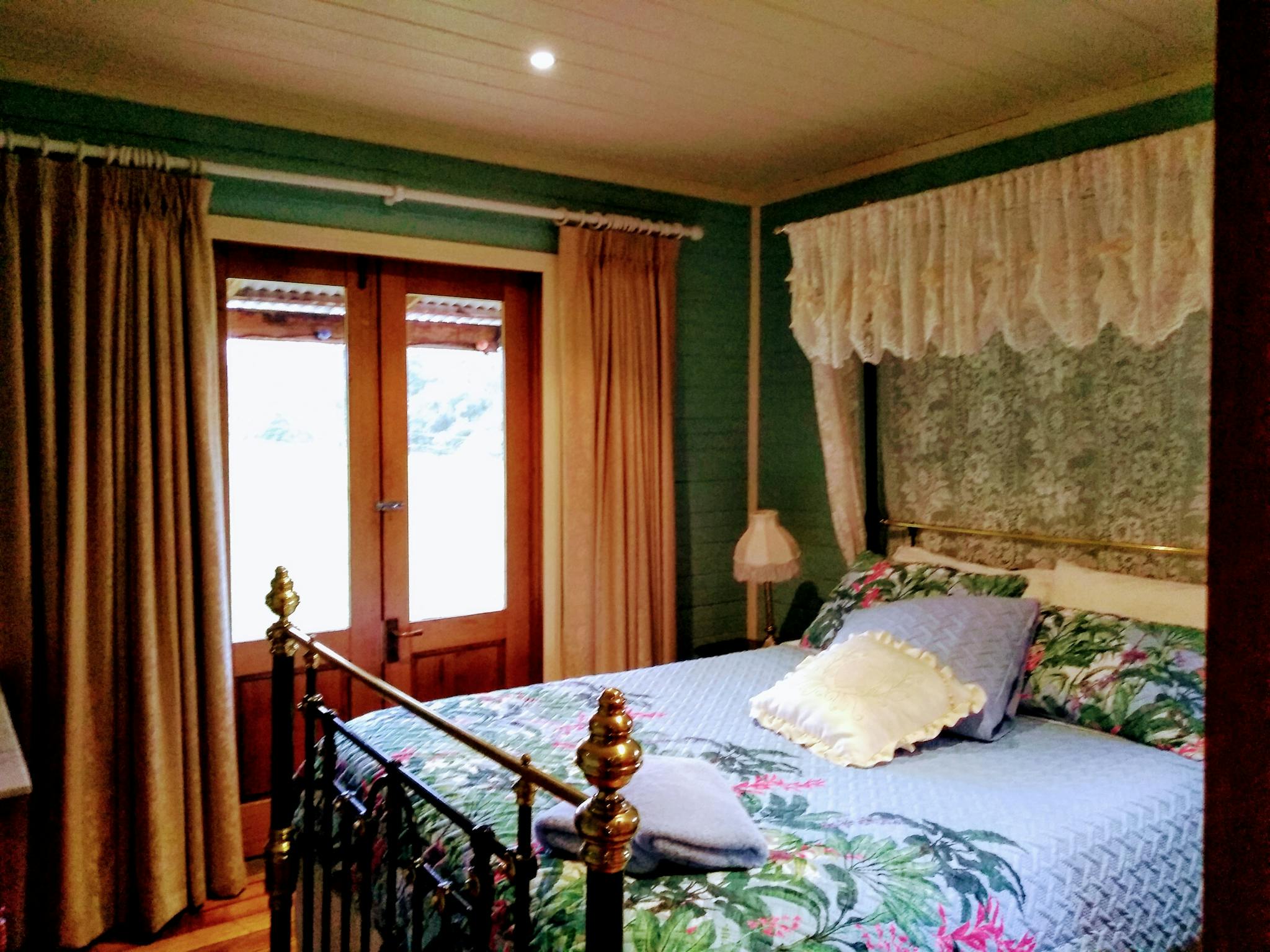 Orchard Cottage bedroom 1, antique queen bed with quality linen and rural outlook