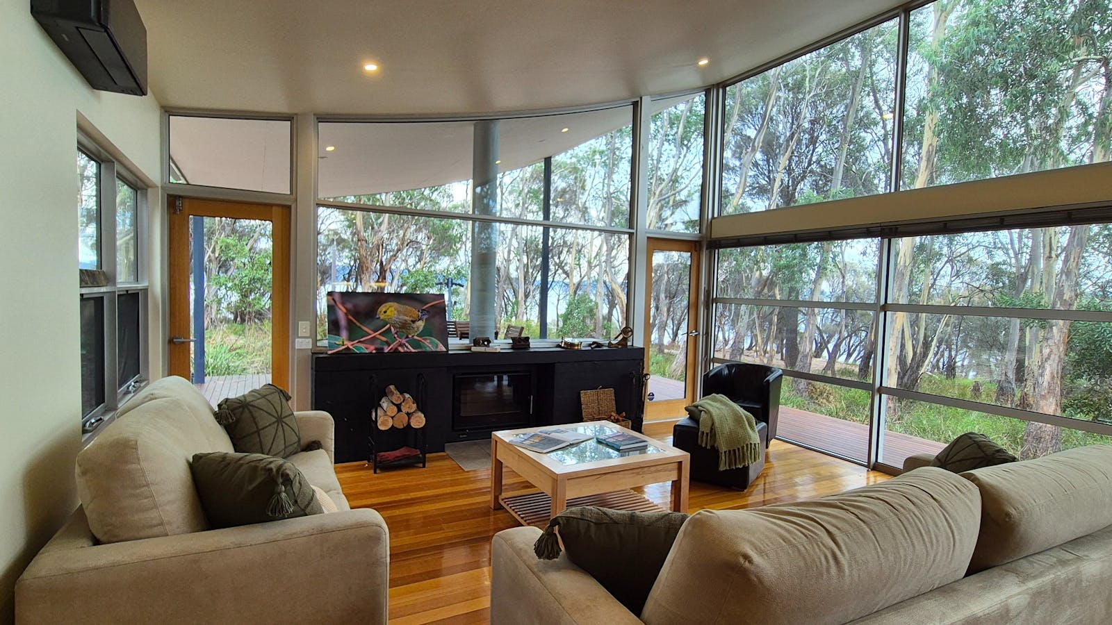 Living room with fireplace, view to the BBQ area and alfresco and ocean views