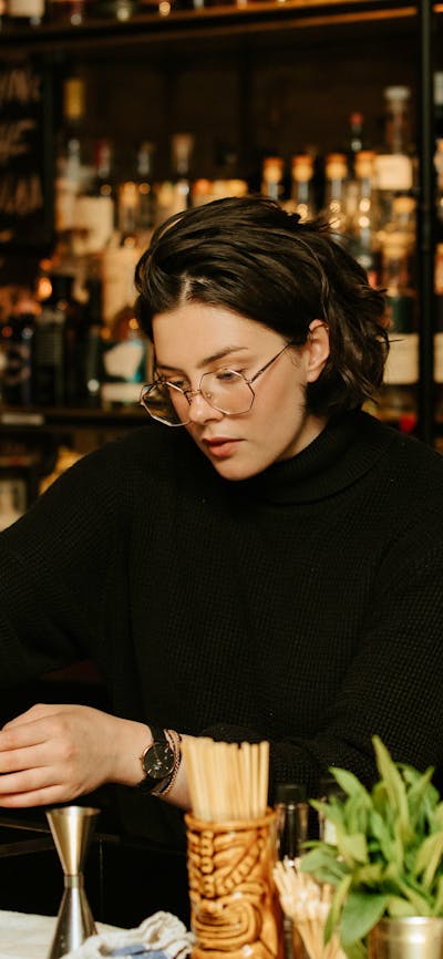 Person making a cocktail at a bar
