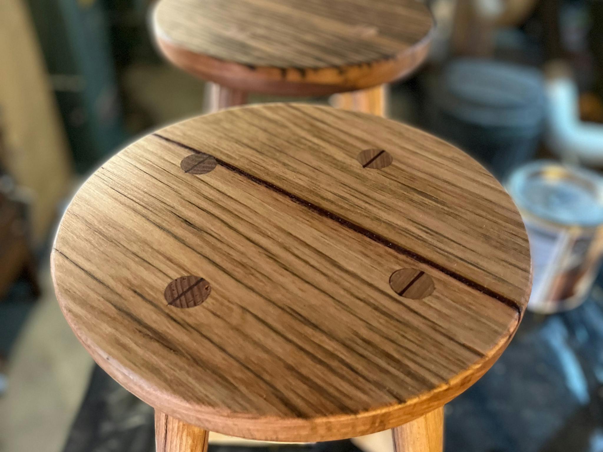 Wooden four legged stool with recycled timber tops.