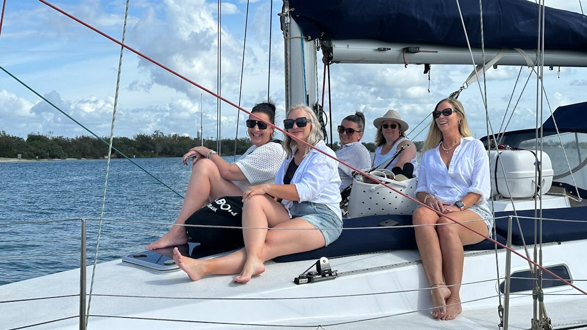 Group of women friends sitting on the deck of Sun Sailing's yacht heading out on an afternoon cruise