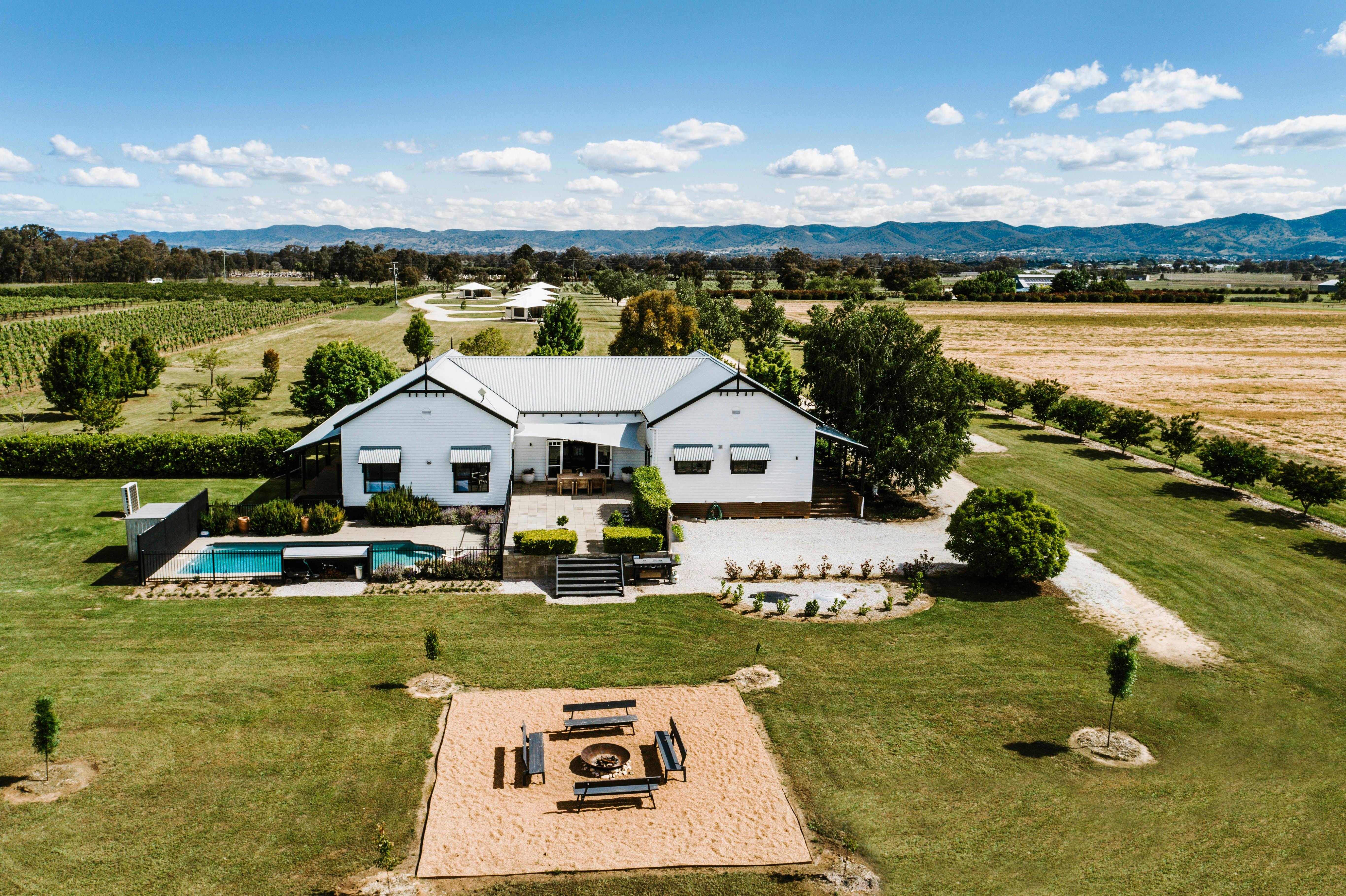 large country style farmhouse with a pool and outdoor fire pit