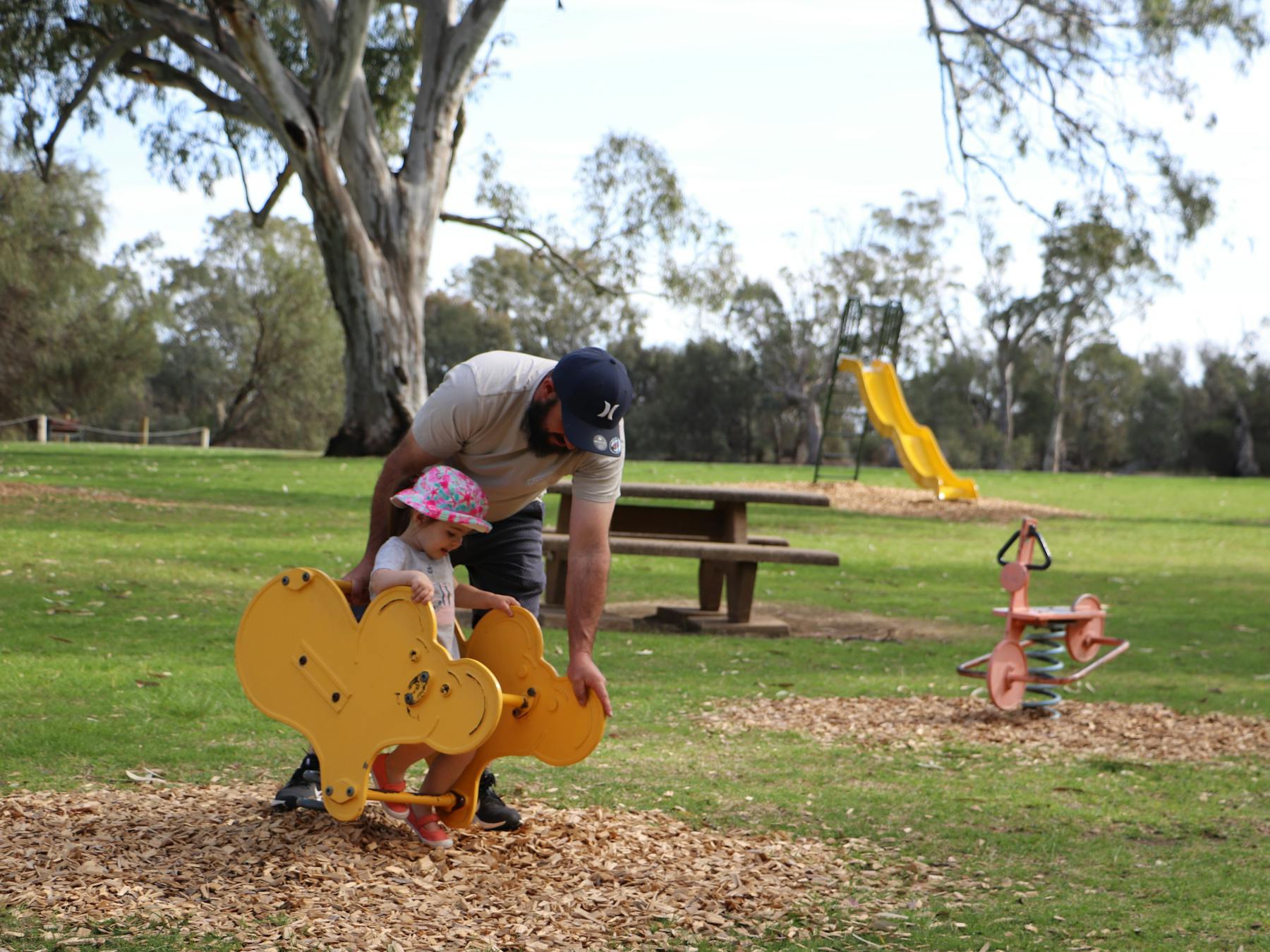 The spacious park boasts large lawn areas and a playground.