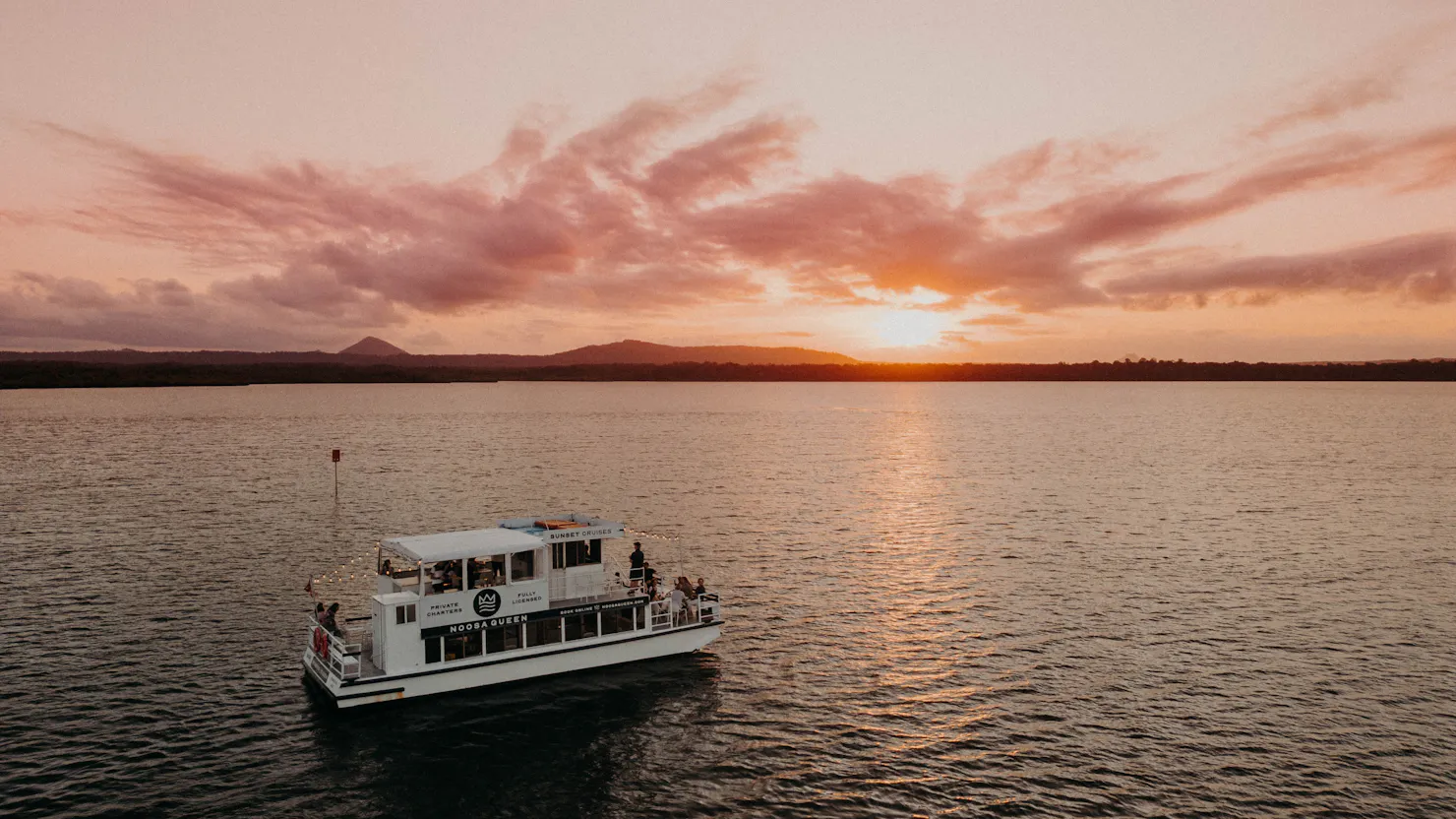 The Noosa Queen on Lake Cooroibah with the sun setting in the background