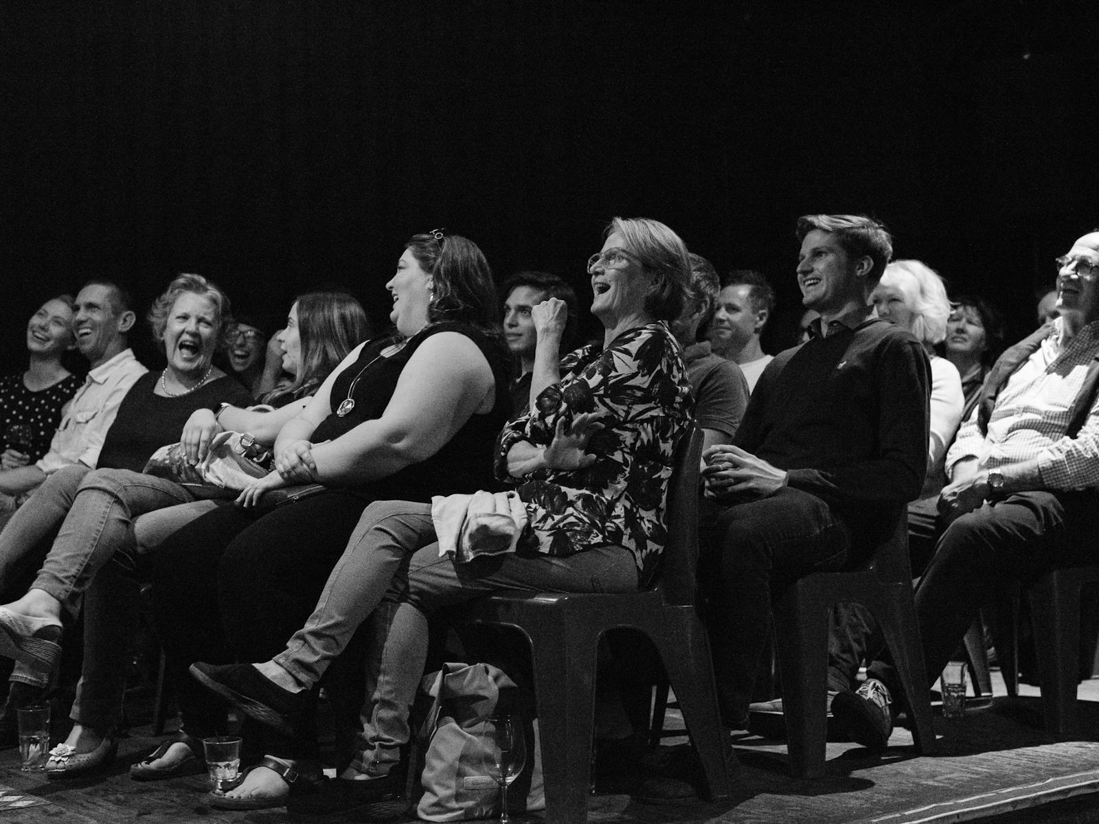 a crowd laughing at a comedy show