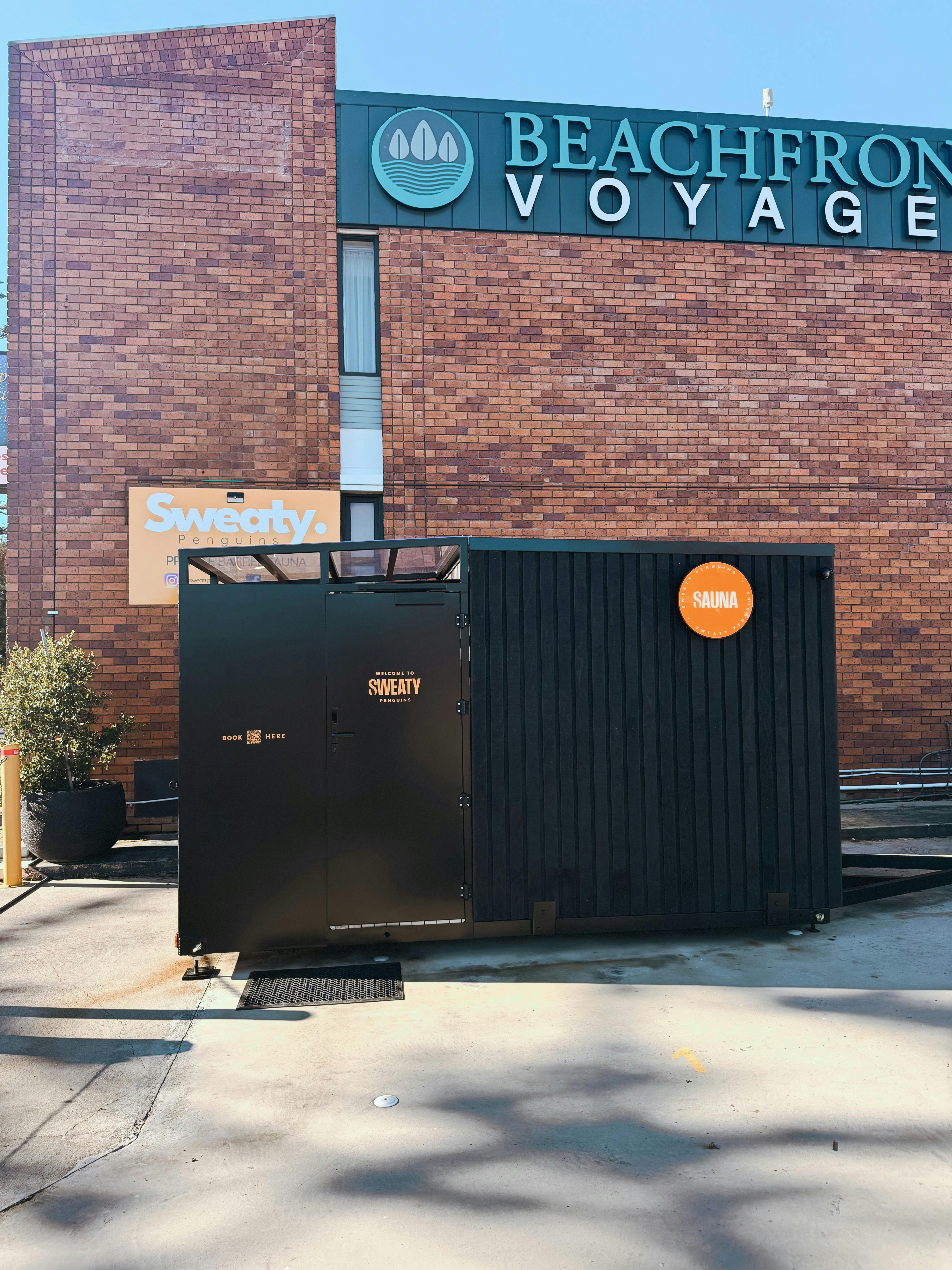 Side exterior view of the Sweaty Penguins private sauna at Burnie, with black cladding.