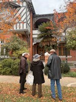 A couple and guide stand outside a historical building on a architectural tour of Wagga Wagga