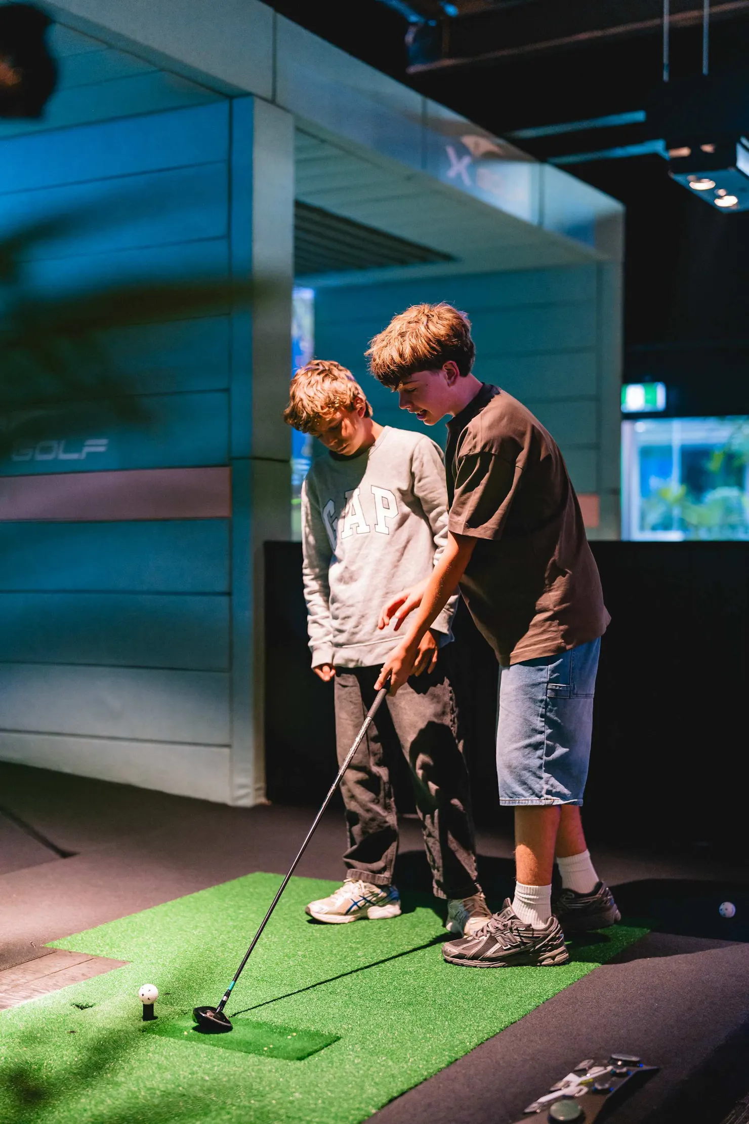 Two Kids Playing Indoor Golf Simulator