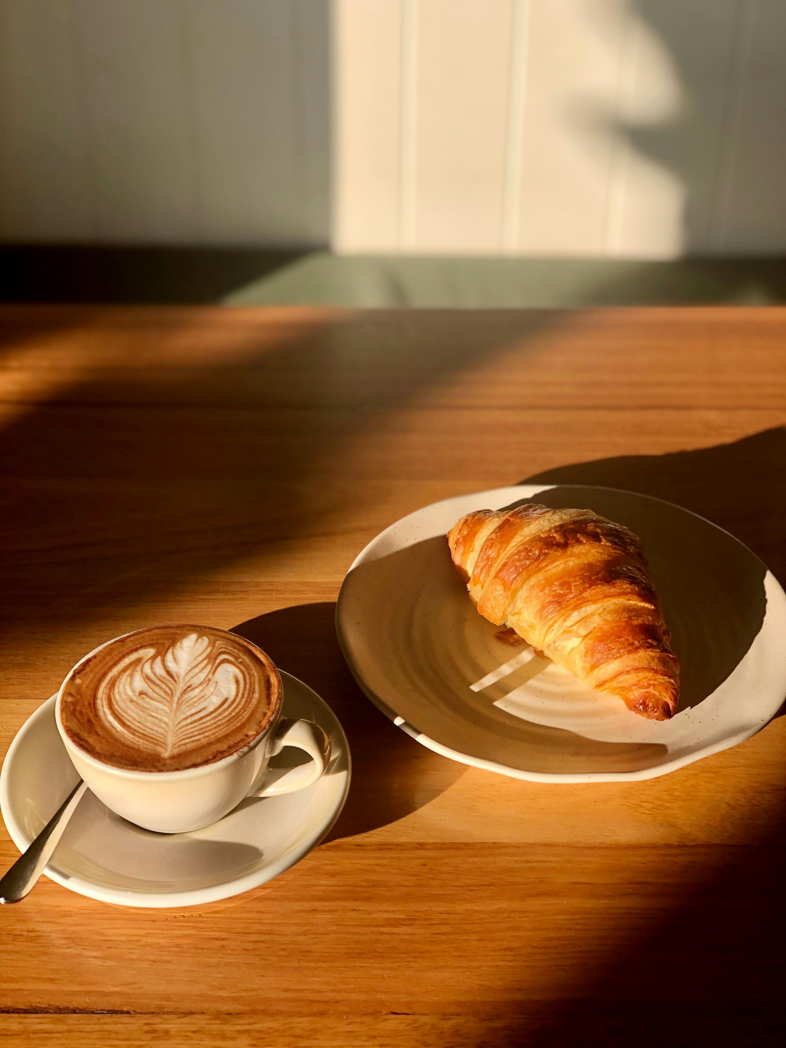 House baked croissants and cappuccino With morning light shining over image