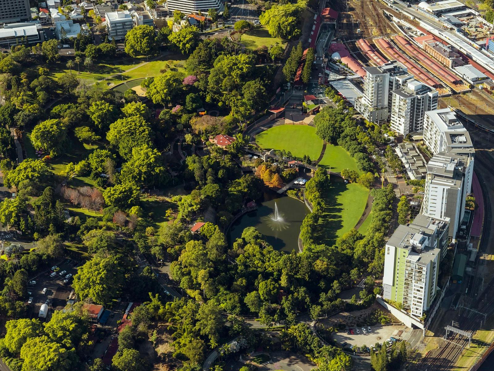 Aerial view of Roma Street Parkland showing dense green spaces of trees and lawn and a lake Aerial view of Roma Street Parkland showing dense green spaces of trees and lawn and a lake