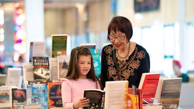 A woman and young girl looking at books in the National Library of Australia Bookshop