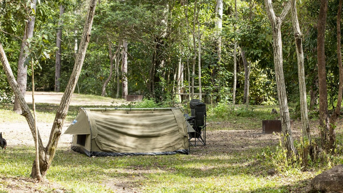 Swag tent pitched beside two camp chairs.