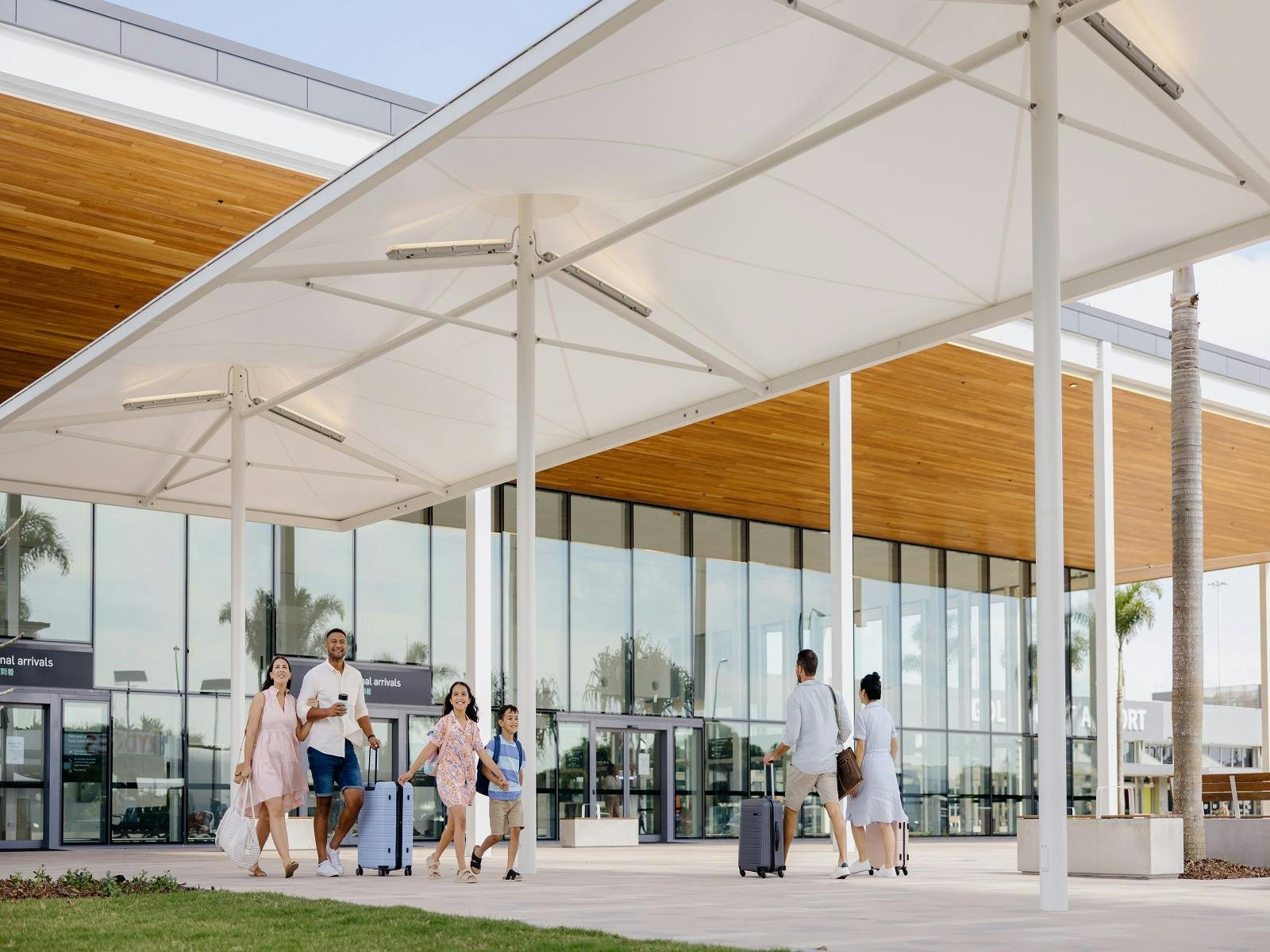 Family arriving to the Gold Coast Airport walking out into international arrivals plaza Family arriving to the Gold Coast Airport walking out into international arrivals plaza