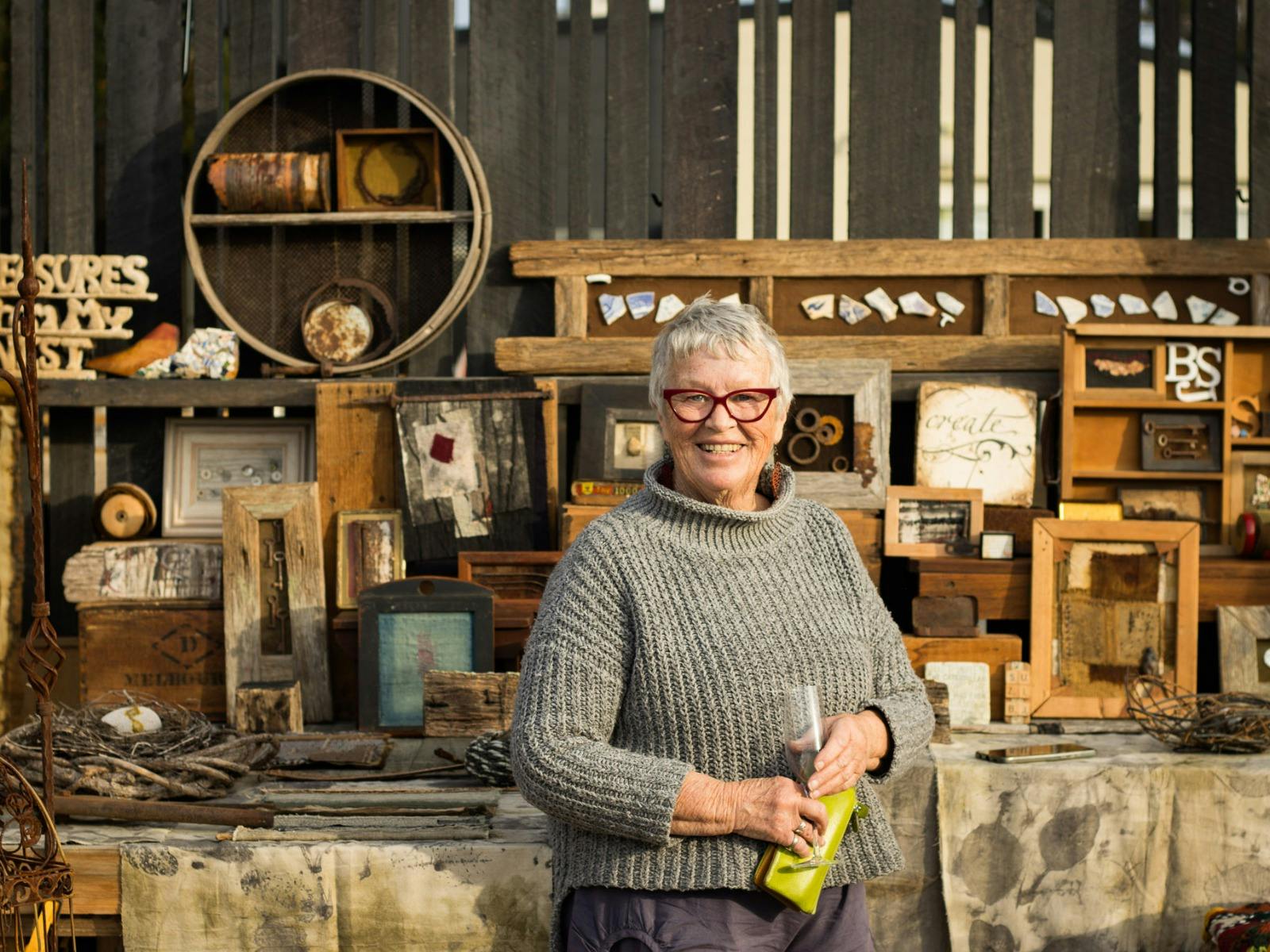 A local artisan beside a handmade art stall in St Helens, Tasmania.