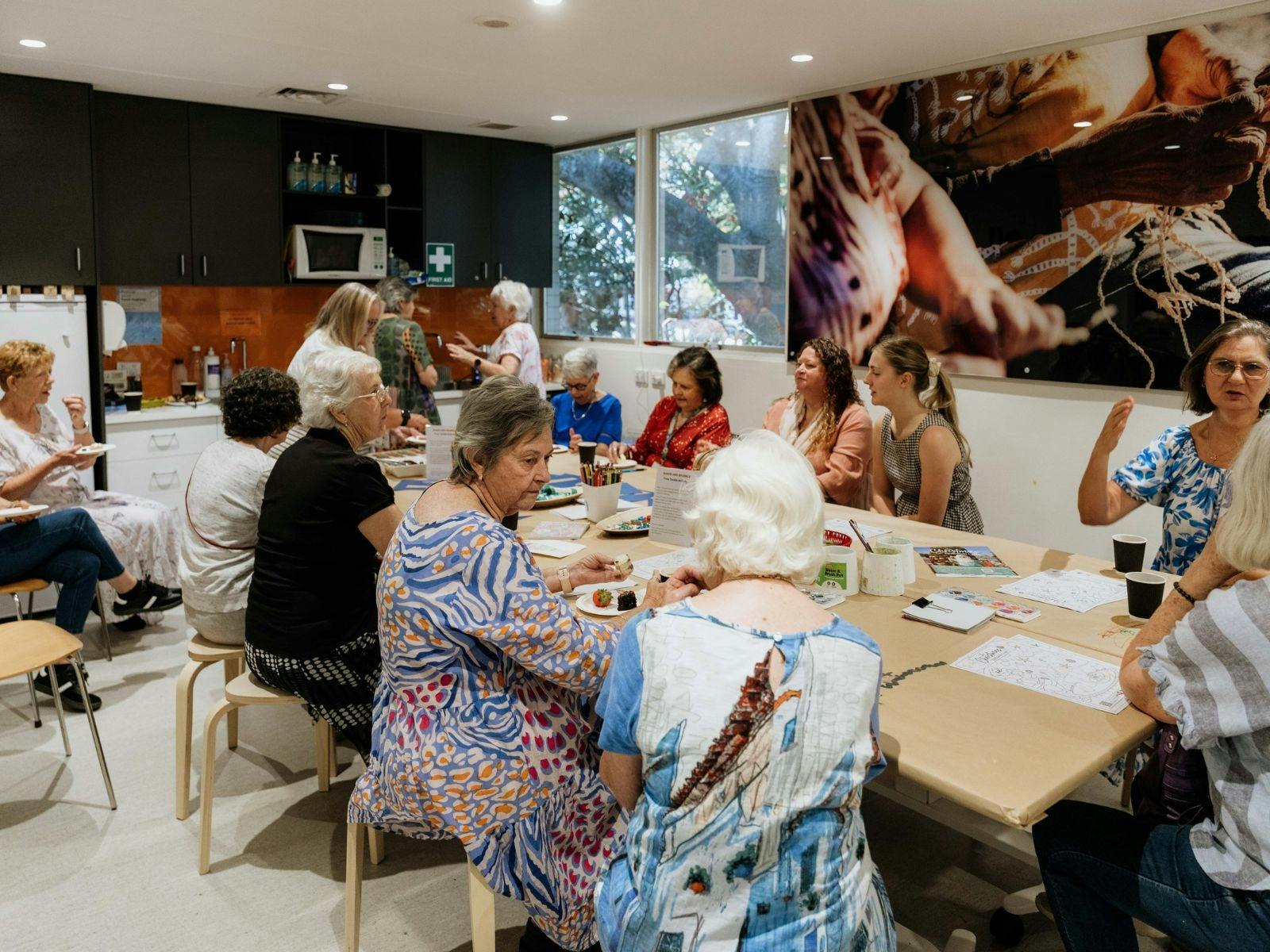 Image of a group of people conversing in an art workshop room