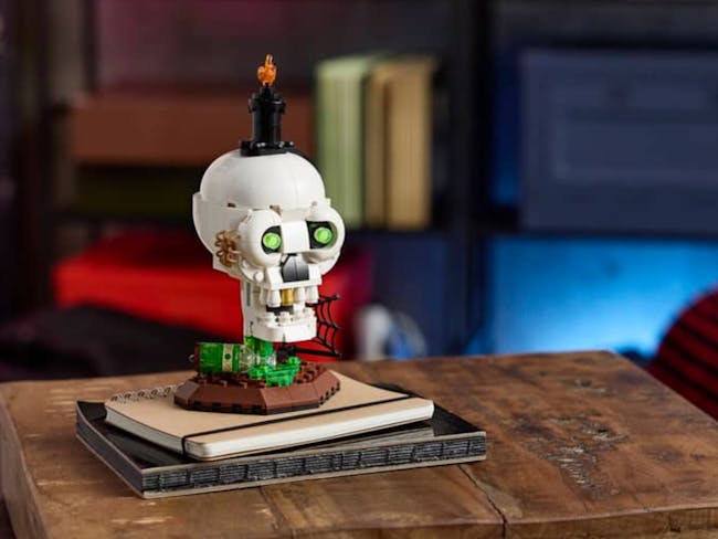 a skull and candle built from Lego bricks on a stack of books
