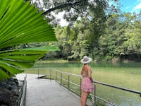 Woman standing at the edge of the Babinda Boulders swimming area with lush rainforest surrounding