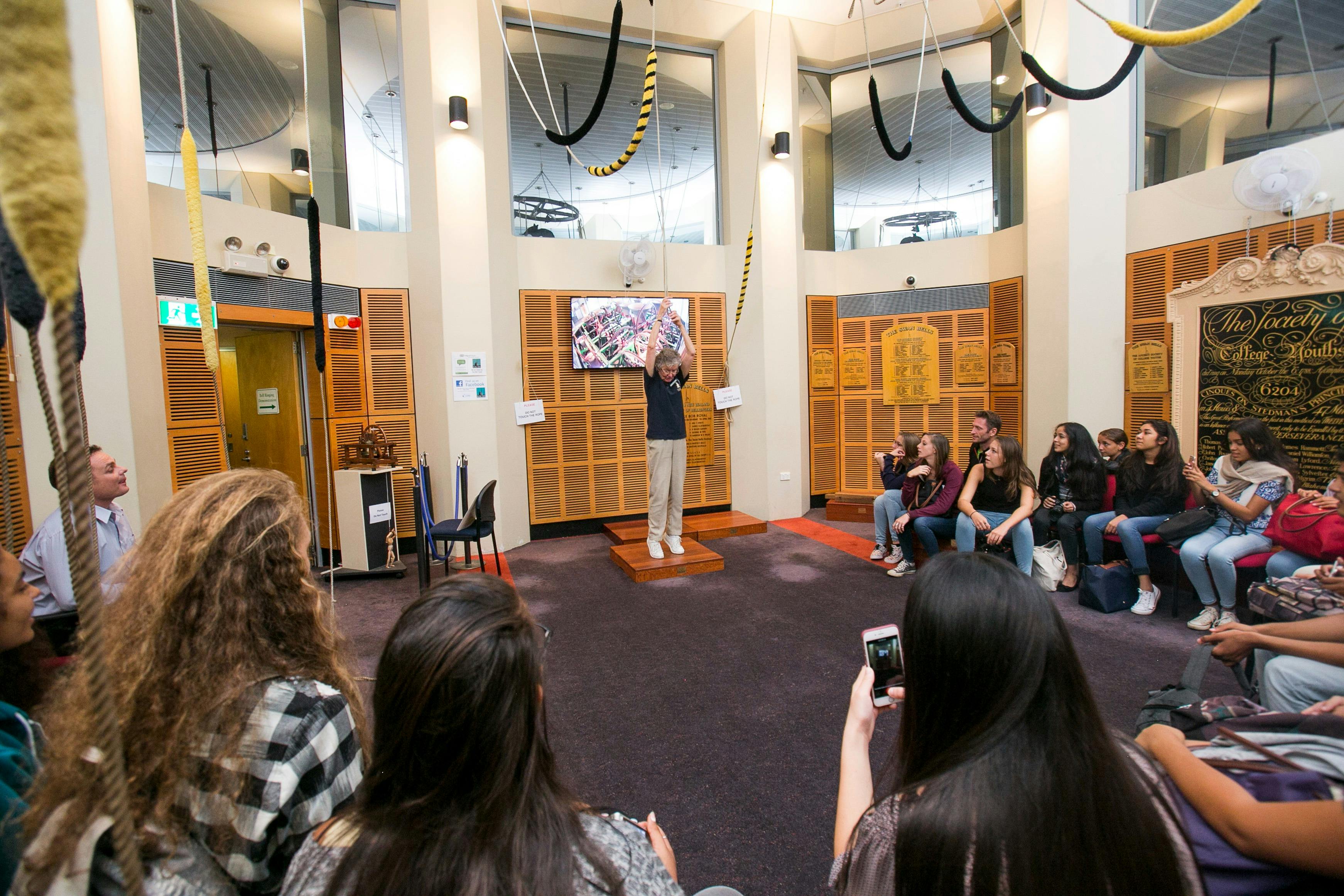 A Bell Tower Ringer demonstrating full-circle ringing to a group of guests.
