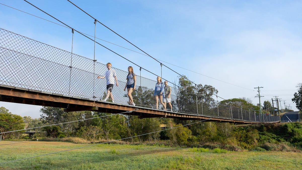 Young travellers walking along a suspension bridge.