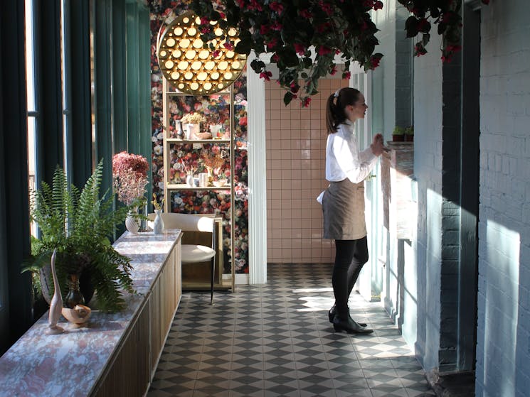 Decorated sunlit hallway with waitress waiting at kictchen window