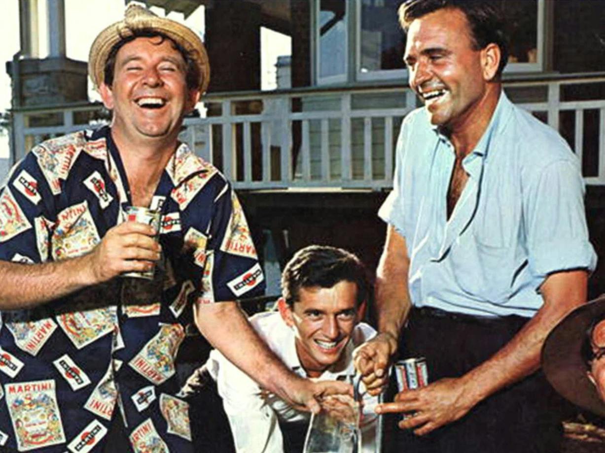 Three men laughing and drinking at the beach