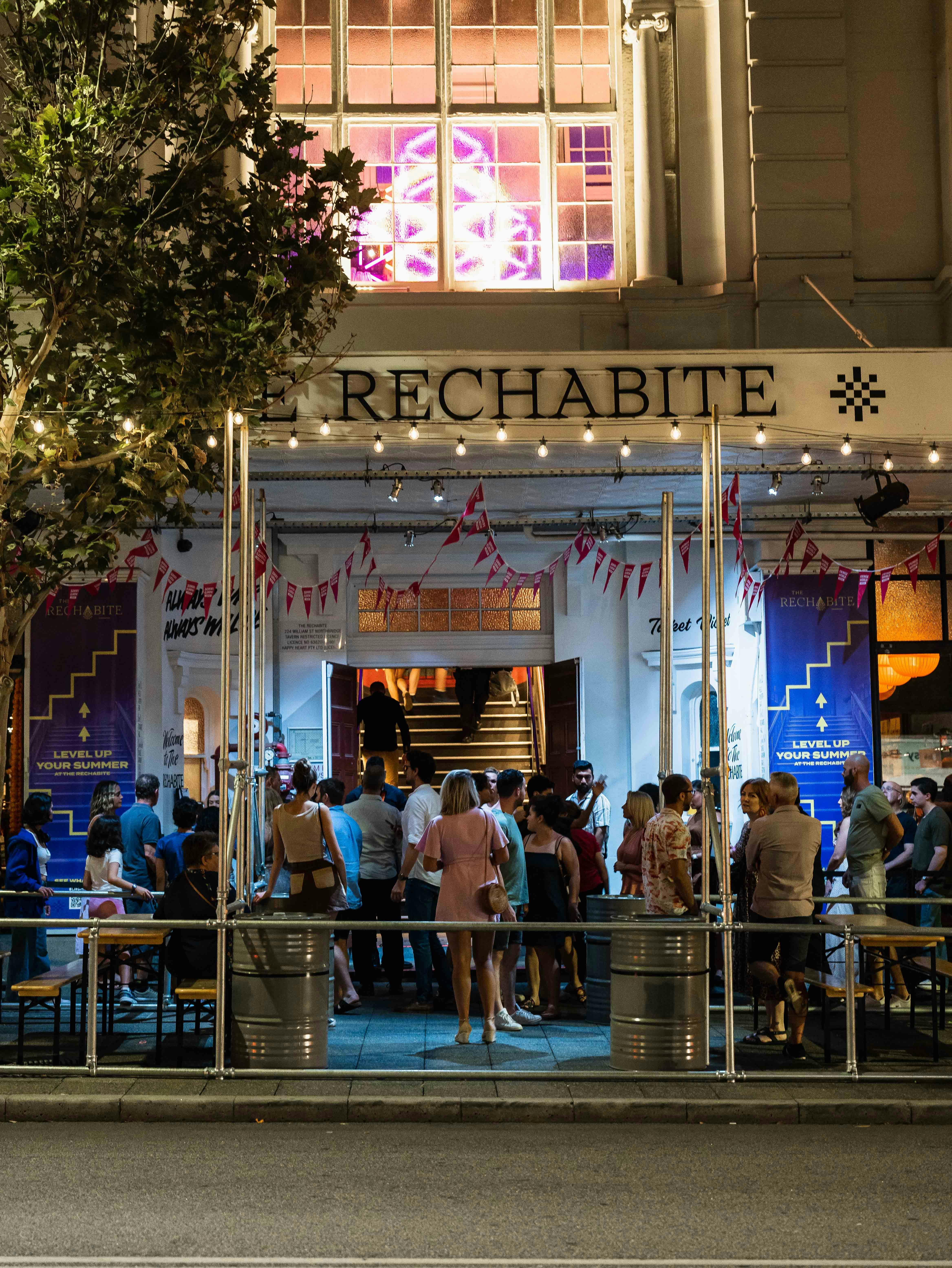 A crowd mingles in The Rechabite alfresco while guests enter for a Fringe show.