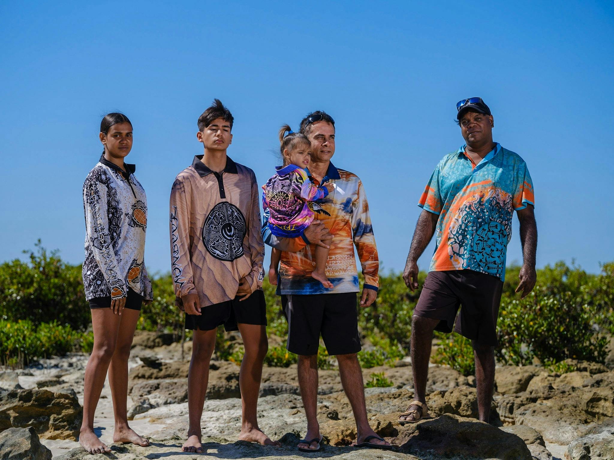 4 people and baby wearing colourful Ardi'ol fishing shirts.