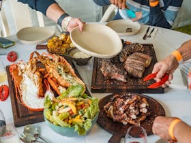 Table Shot with Full Crayfish, Octopus, Mayura Station Beef and Salad with plate ready to be filled.