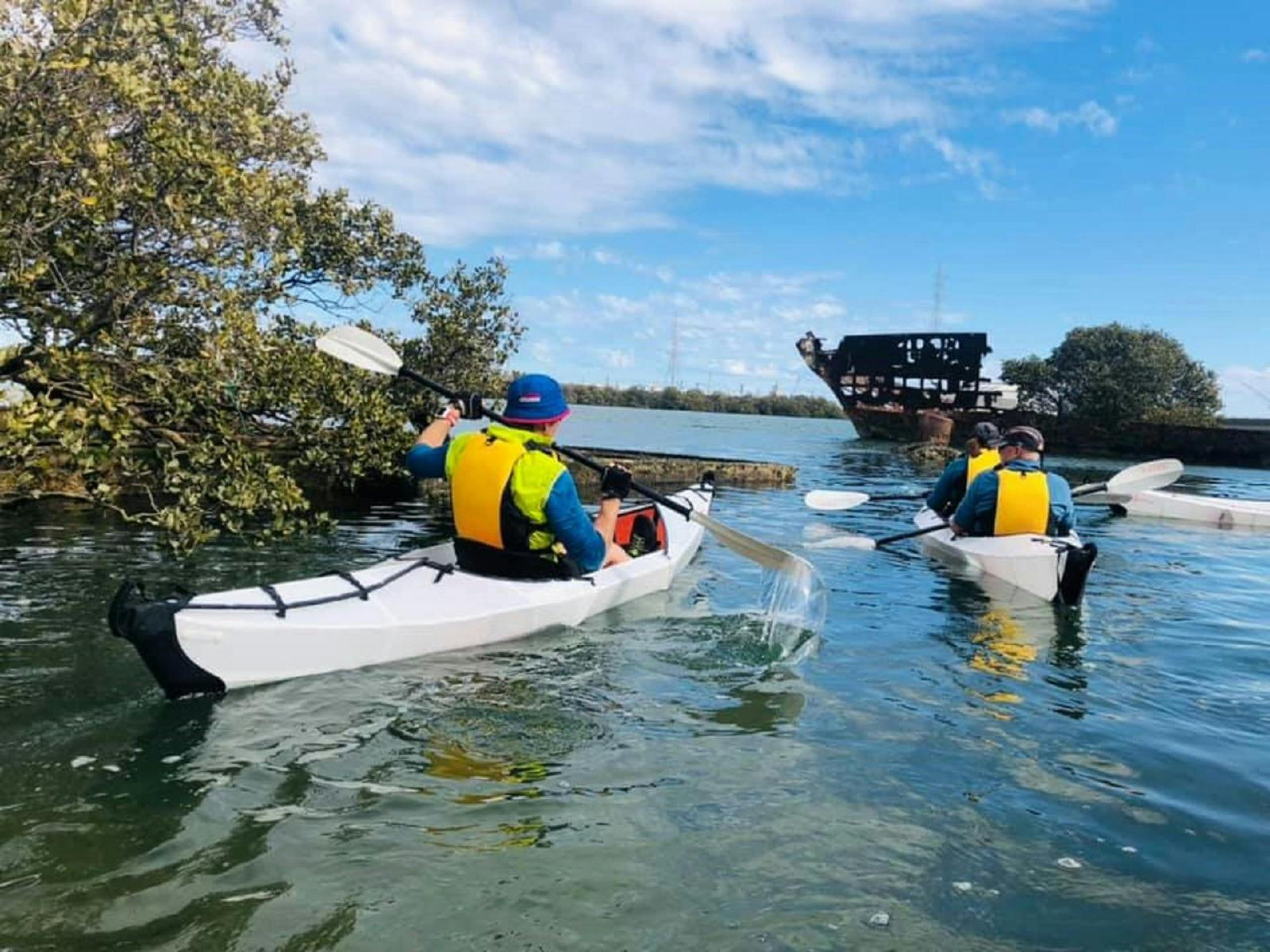 2 kakers paddling amongst old shipwrecks